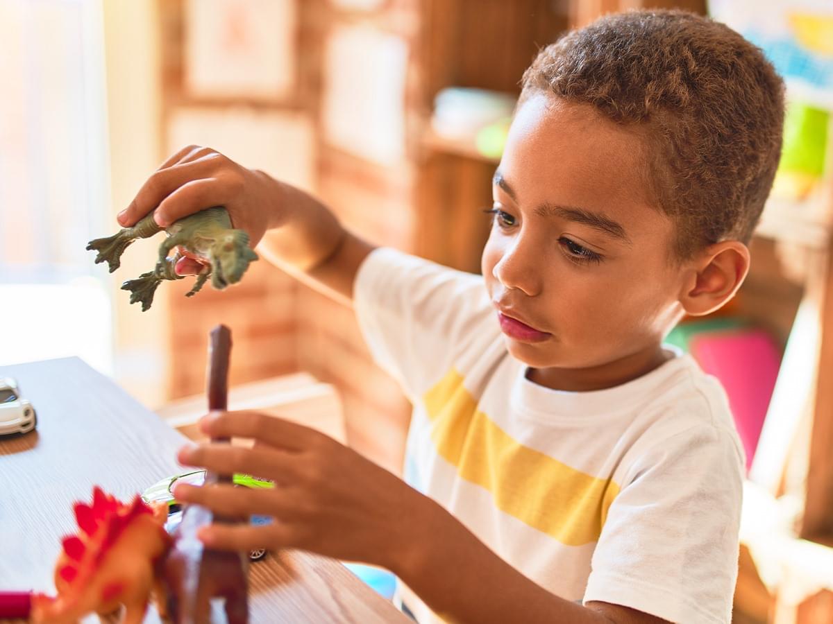 Child playing with dinosaur toy